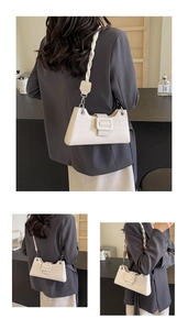 Detailed macro view of white crocodile pattern texture and woven handle on women's shoulder bag