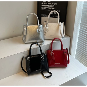 Detail view of four textured mini tote bags in silver white black and red with heart charms