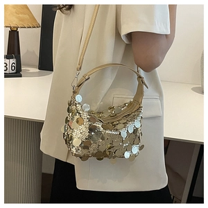 Detail of gold paillette sequins and adjustable crossbody strap on minimalist handbag