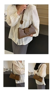 Detail view of brown crocodile texture bag with woven strap and silver buckles