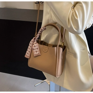 Dettaglio borsa tote in pelle kaki con foulard in seta a scacchi avvolto sul manico