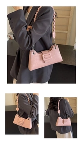 Pink baguette shoulder bag with crocodile texture and woven strap detail