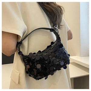 Detailed view of women's black sequin underarm bag showing reflective texture and leather strap
