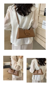 Close-up of brown crocodile pattern shoulder bag with a large decorative square buckle