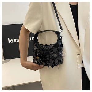 Detail of black sequined shoulder bag showing glossy round sequins and leather strap