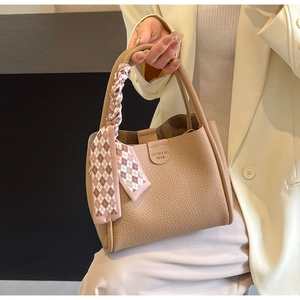 Dettaglio borsa a secchiello kaki in pelle martellata con foulard di seta sul manico