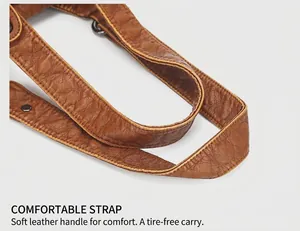 Detail of comfortable brown vintage washed leather strap with dark metal hardware buckle