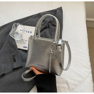 Detail of silver textured bucket bag with heart pendant and FASHION & YM lettering