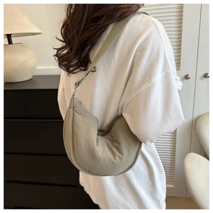 Close-up of olive green crescent shoulder bag in nylon fabric on a model