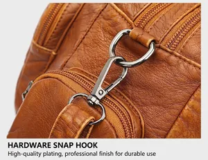 Detail of silver-toned metal hooks and double zippers on brown pebbled leather tote