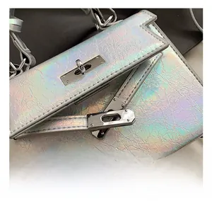 Close-up of the silver metal rotating lock and laser iridescent texture on the fashion bag