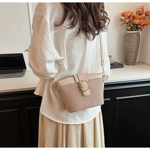 Chic pink woven shoulder bag with gold ring closure shown in a lifestyle office setting