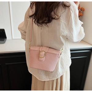 Detailed back view of pink woven texture bucket bag with gold buckle on model