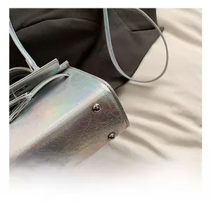 Macro view of metallic silver iridescent leather bag with polished silver base rivets