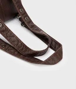 Close-up of brown pebbled leather bag handle with reinforced ergonomic stitching details