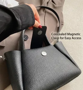 Detail showing the magnetic closure and pebbled leather texture of the black bucket bag