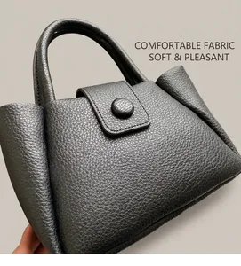 Close-up of black lychee grain bucket bag featuring a flap closure and round buckle