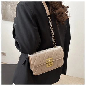 Detail der champagnerfarbenen Stepptasche mit goldenem Schloss und Kettenriemen