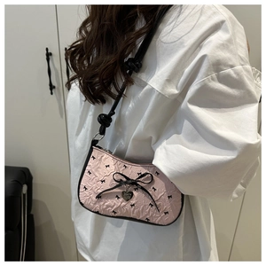 Sac baguette rose avec texture plissée et détails de nœuds noirs élégants