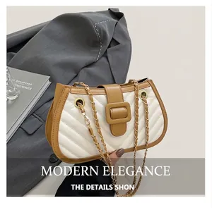 Detail of two-tone quilted leather bag with V-shaped stitching and gold chain strap