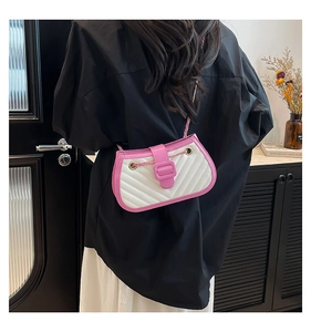 Détail d'un petit sac bandoulière avec matelassage en V blanc et accents roses