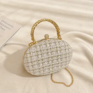 Detail of white woven evening clutch with gold handle and pearl clasp with chain