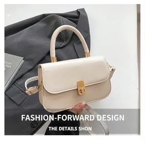 Detail of cream saddle bag featuring a gold rectangular twist lock and top handle