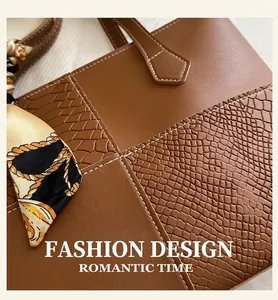 Detail of caramel tote bag with mixed leather textures and printed silk scarf on handle
