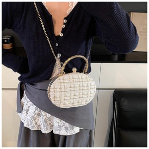 Detailed view of tweed crossbody bag with gold chain and diamond-encrusted clasp