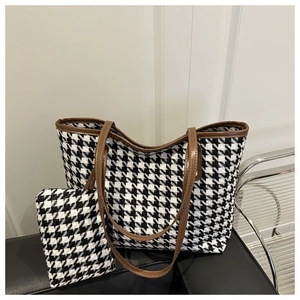 Detalle del bolso tote de tweed a cuadros con asas de cuero marrón y estuche a juego