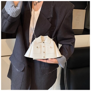 Detail of creative white jacket-shaped crossbody bag with silver chain and button accents