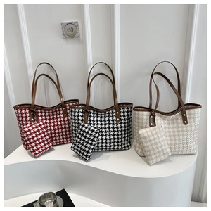 Vista detallada de tres bolsos tote grandes con pata de gallo en rojo, negro y beige