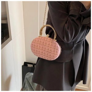 Detail van roze tweed avondtas met gouden metalen handvat en kettingriem