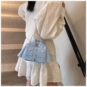 Detail of light blue jacket-style mini crossbody bag with metal chain on a model