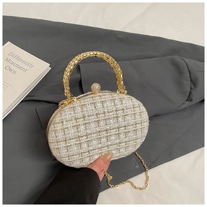 Detail of cream tweed shoulder bag with gold metal handle and rhinestone ball clasp