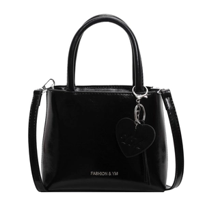 Glossy black leather bucket bag with silver hardware and heart charm on white background
