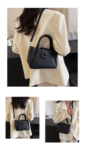 Close-up of black lychee grain leather bucket bag with round handle and detachable strap