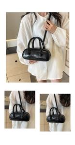 Detail of black glossy bowling bag showing shiny wrinkled leather and silver hardware