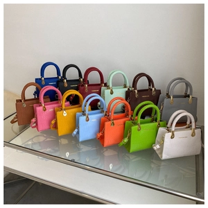 Macro shot of stylish crocodile pattern mini tote bags with braided handles in various colors