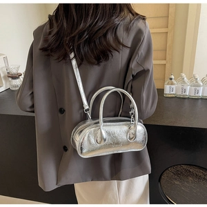 Silver metallic wrinkled leather bowling bag shown with hand strap and crossbody style