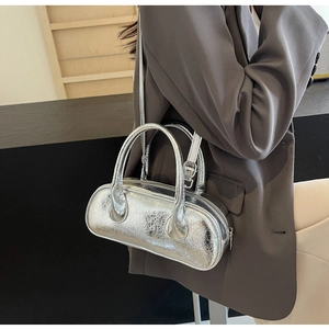 Close-up of a silver metallic bowling bag featuring a glossy pillow shape and adjustable strap