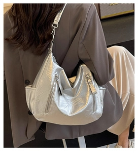 Close-up of a silver hobo bag with natural leather texture and stylish double zipper detail