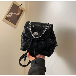Detail eines schwarzen gesteppten Tunnelzug-Rucksacks mit Silberverschluss und Kette