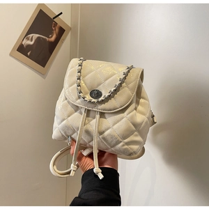 Detail eines perlweißen gesteppten Rucksacks mit silberner Kette und Metallverschluss