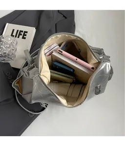 Interior view of silver crescent bag showing large capacity for umbrella and phone