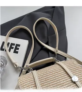 Detail of beige straw shoulder bag with leather straps and metallic buckle detail