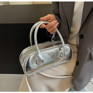Silver metallic crinkle leather bowling bag shown with neutral minimalist business attire