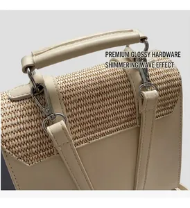 Detail of beige woven straw and smooth leather handbag with shiny silver metal hardware