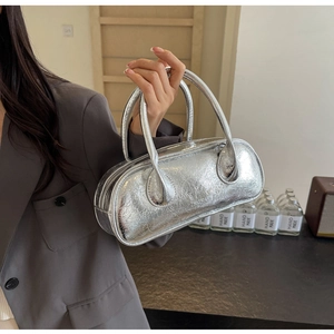 Detail of silver metallic wrinkled texture and logo on this bowling baguette handbag