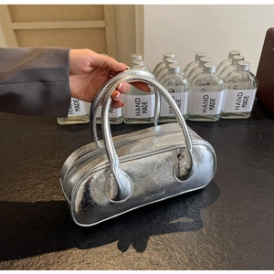 Detail of silver metallic boston bag showing unique crinkle texture and embossed logo